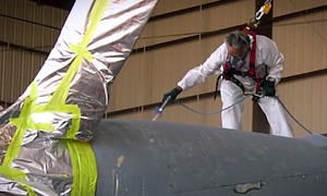 Photo of an engineer on top of a plane with a link to YouTube video about coatings